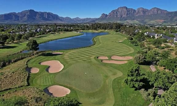 Aerial view of a golf hole beside a lake with Winelands mountains behind, Western Cape